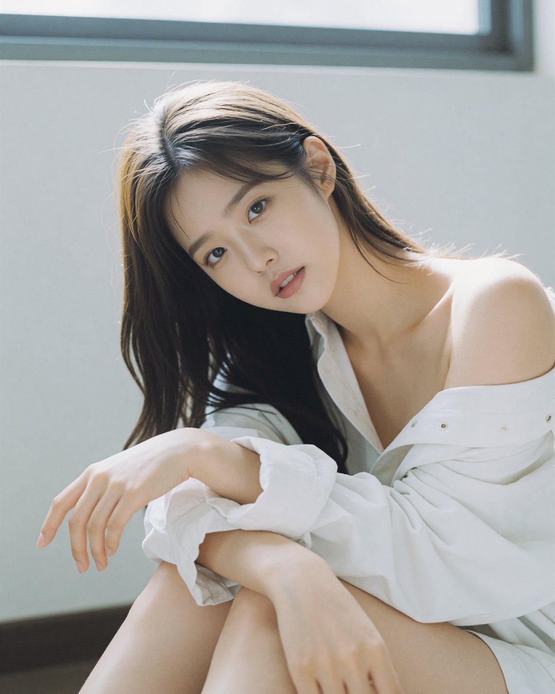 SEOA in a white blouse beside a window